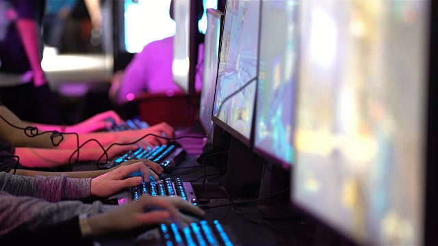 Students competing side by side at neon-lit gaming PCs